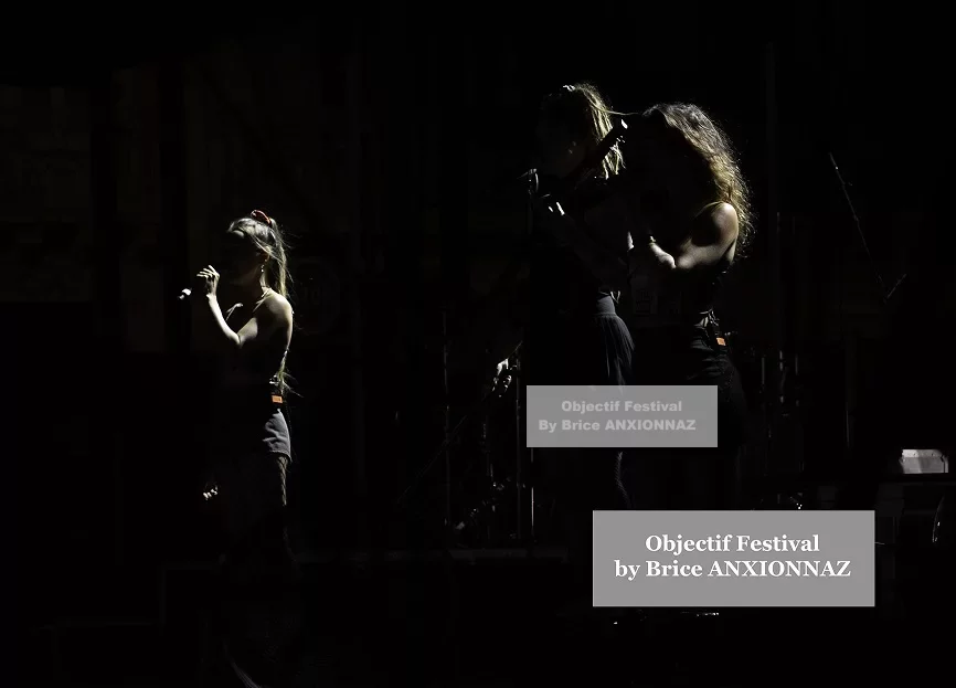 Des silhouettes de trois personnes se tiennent sur scène, éclairées par des lumières tamisées, créant une ambiance mystérieuse au festival. Lej, Hyeres (06/08/2024)